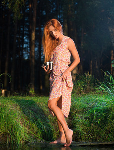 Hot redhead Michelle H wanders through lush countryside with her camera